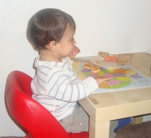 infant sitting on chair eating